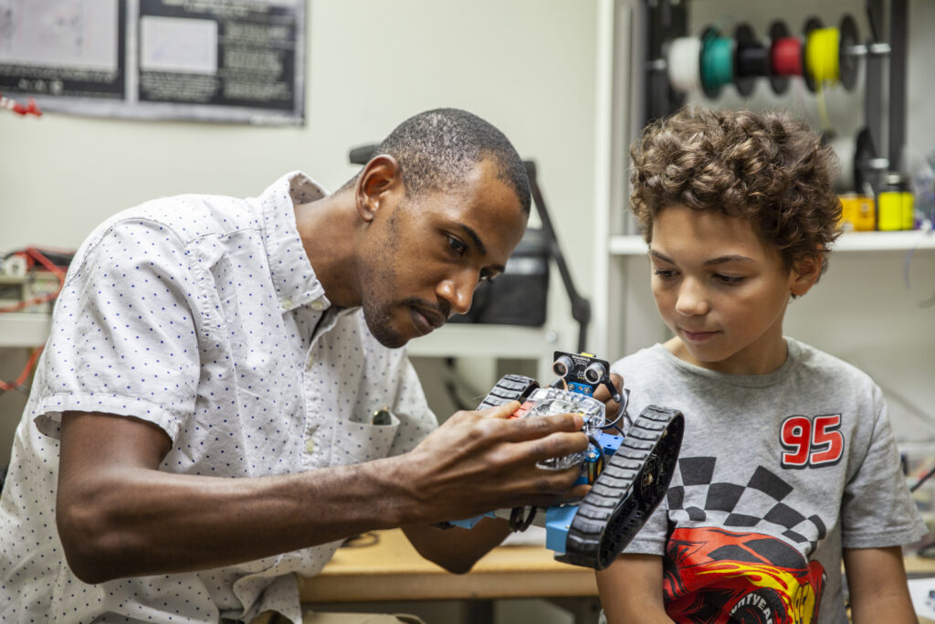 Big Brother and Little Brother tinkering with a robot